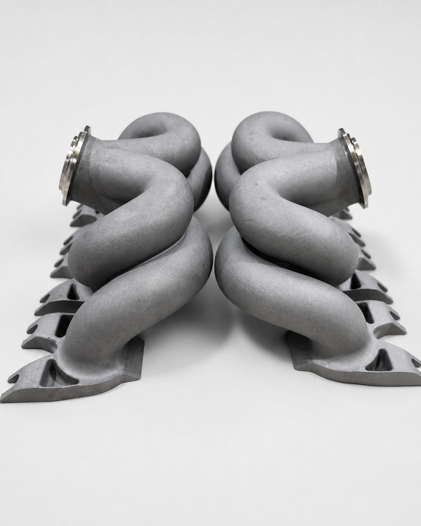 Rear view of ModalWorks equal-length M177 exhaust manifold pair — crossing, equal-length runners mirrored left and right
