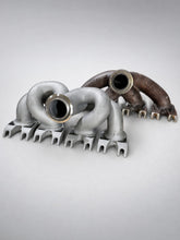 Load image into Gallery viewer, Three-quarter view: ModalWorks M177 equal-length exhaust manifold beside the OEM cast manifold